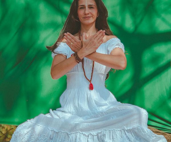 Person sitting in a calm meditative yoga pose outdoors.